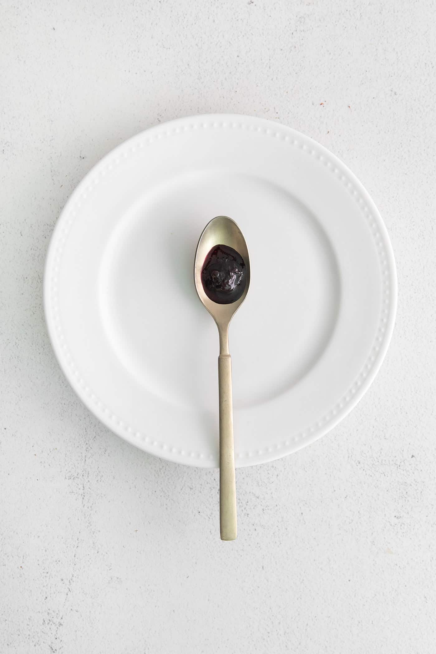 Made with just 4 ingredients, this Homemade Blueberry Jam with Mint is dark and fruity, with a sweet but cool and refreshing flavor. Blueberry jam on a spoon