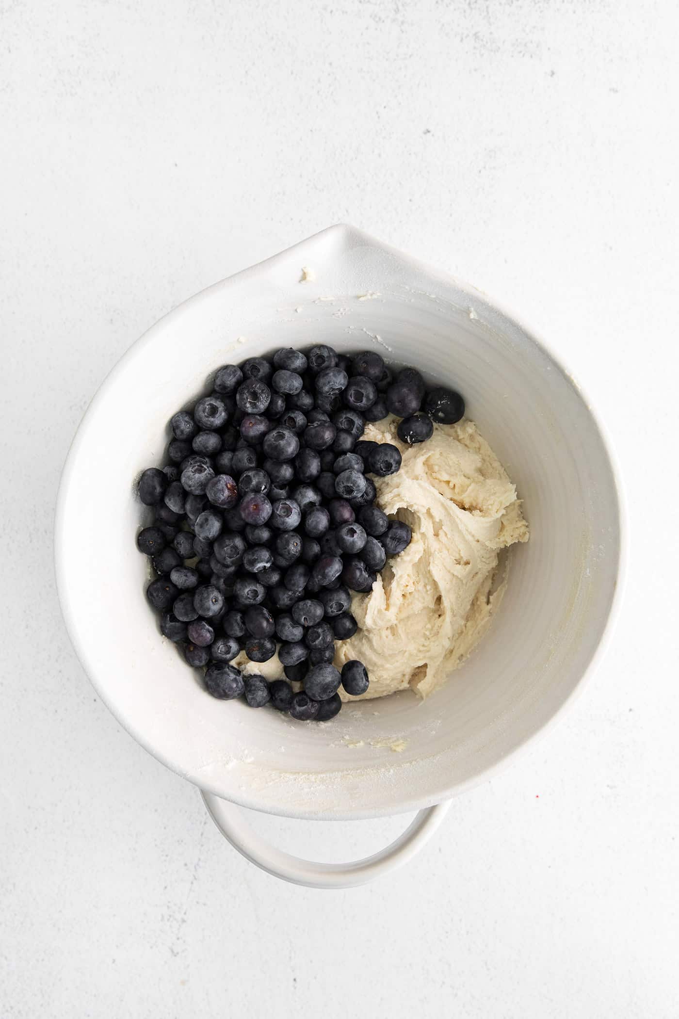 Moist, fluffy, and laced with blueberries in every bite, this Blueberry Tea Cake makes a quick and easy summer dessert. Blueberries added to cake batter in a mixing bowl