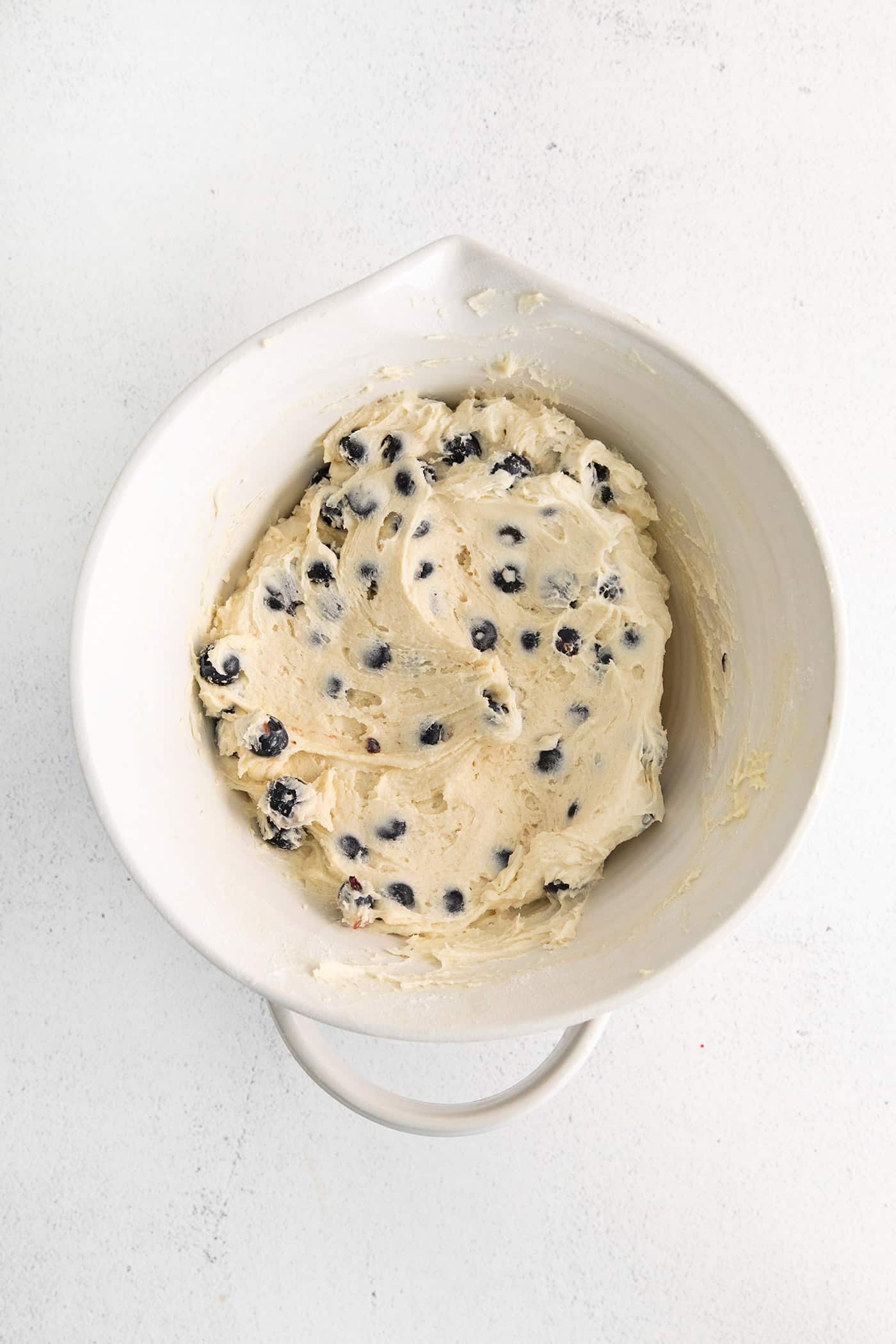 Moist, fluffy, and laced with blueberries in every bite, this Blueberry Tea Cake makes a quick and easy summer dessert. Blueberry tea cake batter in a mixing bowl