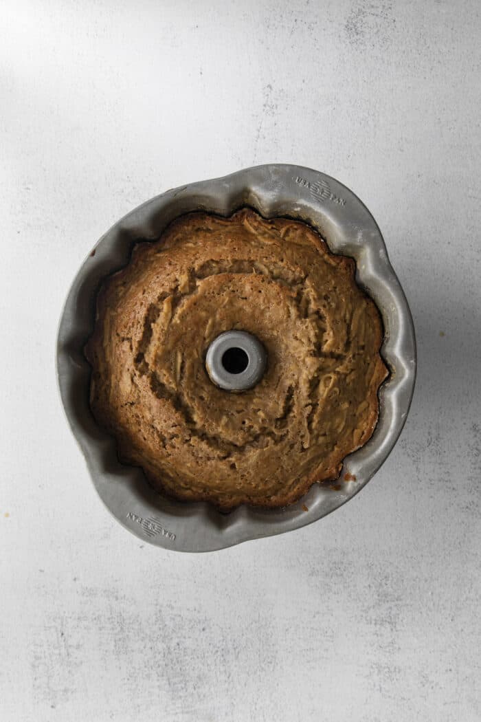 This easy apple bundt cake was made for fall baking! A moist and fluffy apple cake drizzled with an irresistible brown butter vanilla glaze. Baked Apple Bundt Cake in a pan
