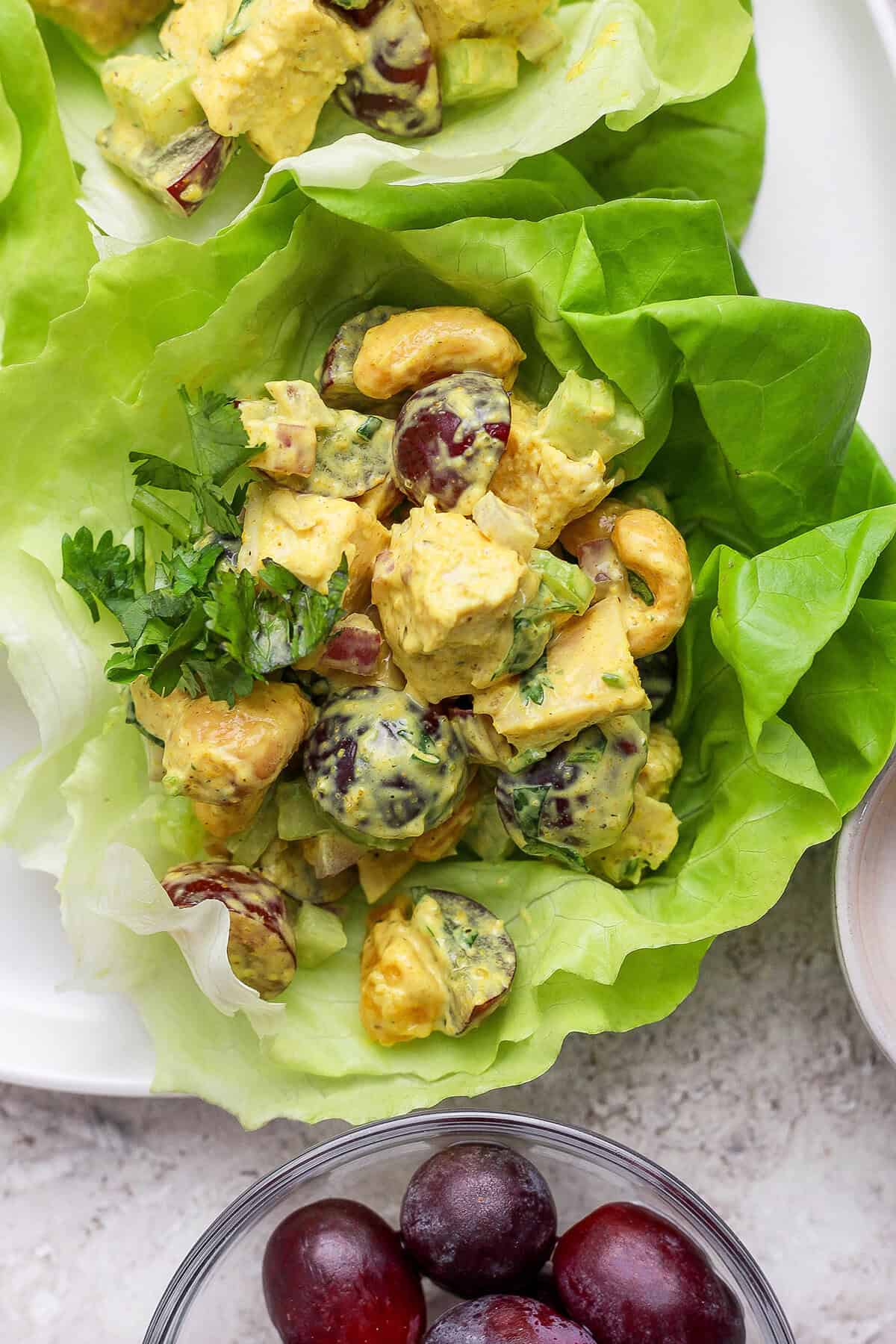 This easy Curry Chicken Salad recipe is the perfect blend of sweet and savory, with juicy grapes, cashews, and a creamy curried dressing. Overhead view of curry chicken salad in lettuce leaves