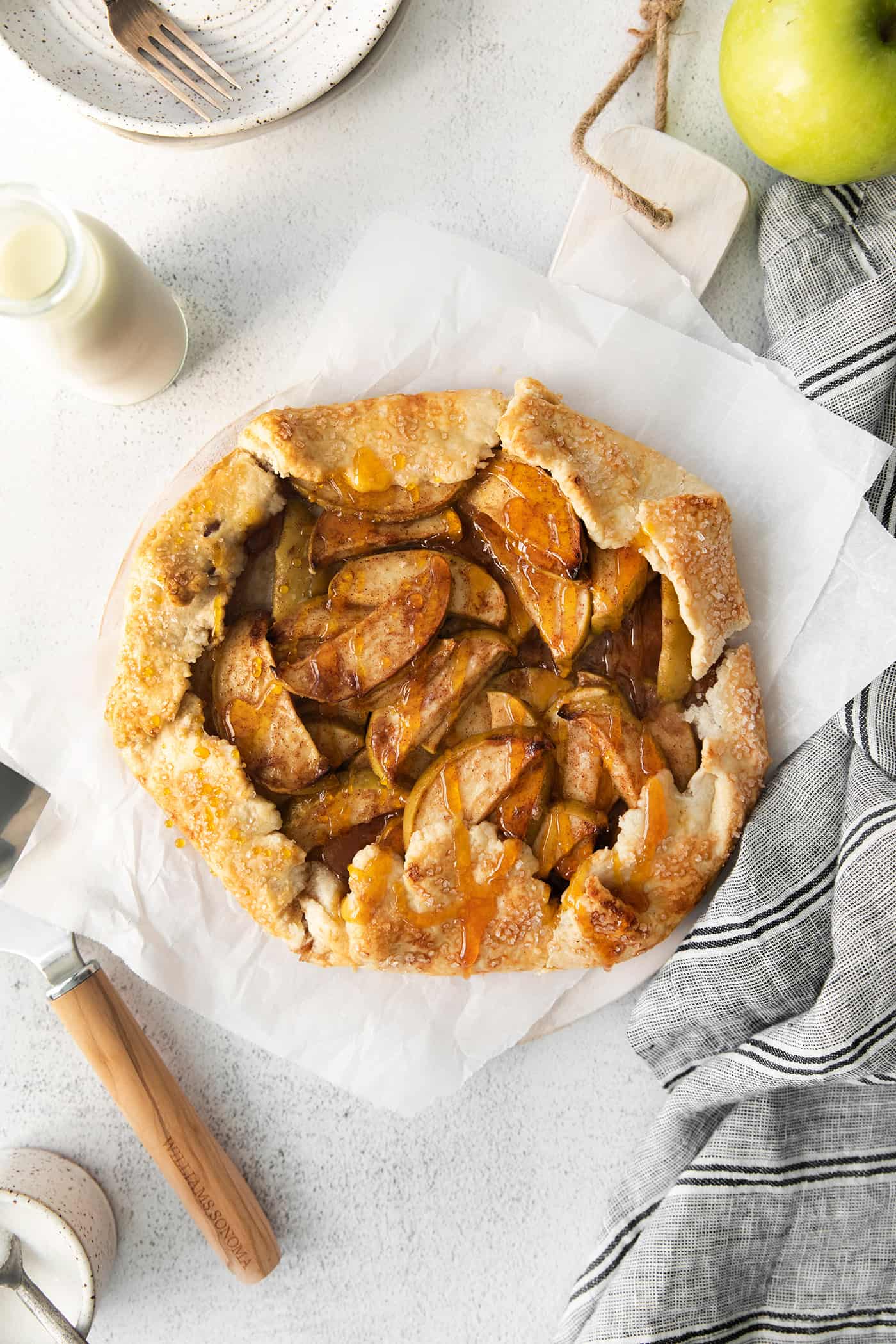 This rustic apple galette has warm cinnamon apples, a buttery crust, and an almond caramel drizzle. It's quicker and easier than apple pie! Overhead view of an apple almond galette