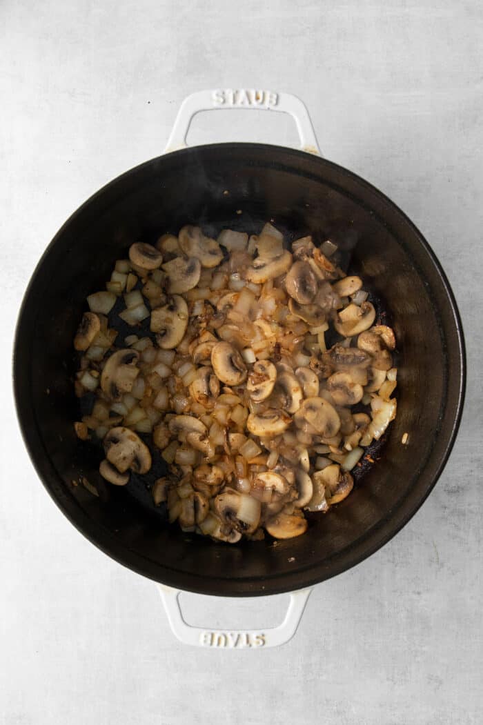 This Bacon Cheeseburger Soup is loaded with your favorite burger ingredients and toppings, like bacon, mushrooms, and a handful of seasonings. Top with shredded cheese and dill pickles for a soup that tastes just like your favorite cheeseburger! Cooked ground beef and mushrooms in a pot