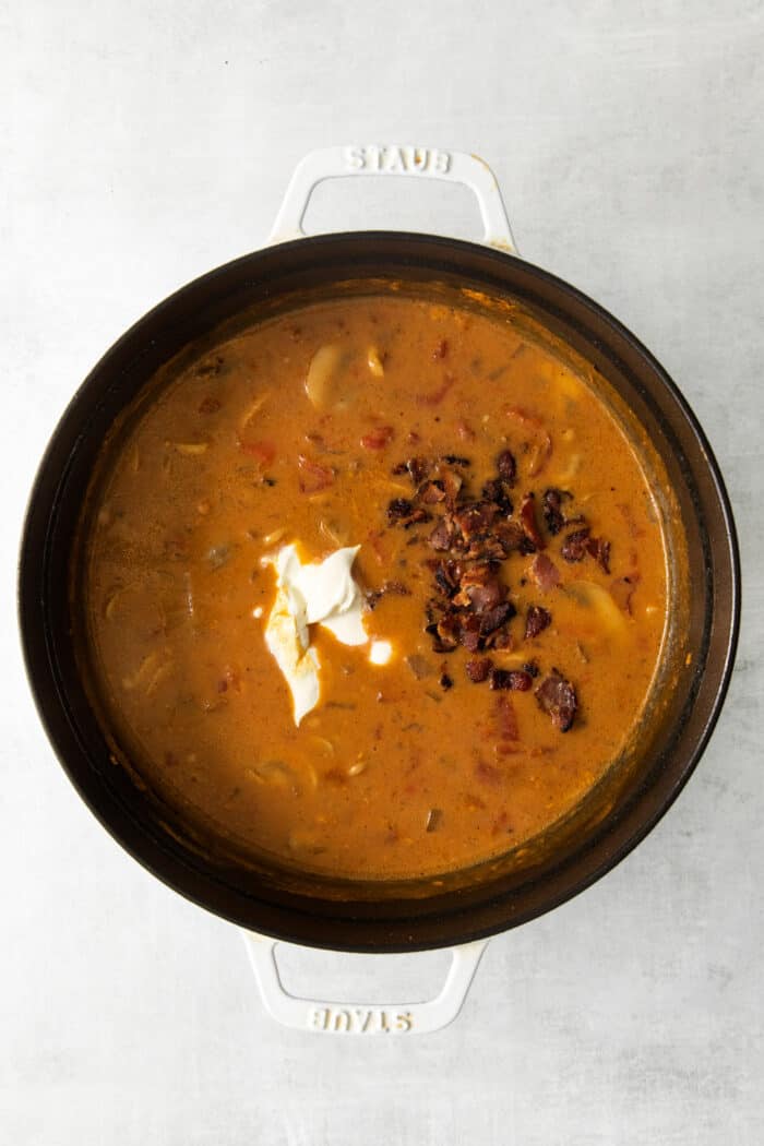 This Bacon Cheeseburger Soup is loaded with your favorite burger ingredients and toppings, like bacon, mushrooms, and a handful of seasonings. Top with shredded cheese and dill pickles for a soup that tastes just like your favorite cheeseburger! Cheeseburger soup ingredients in a pot
