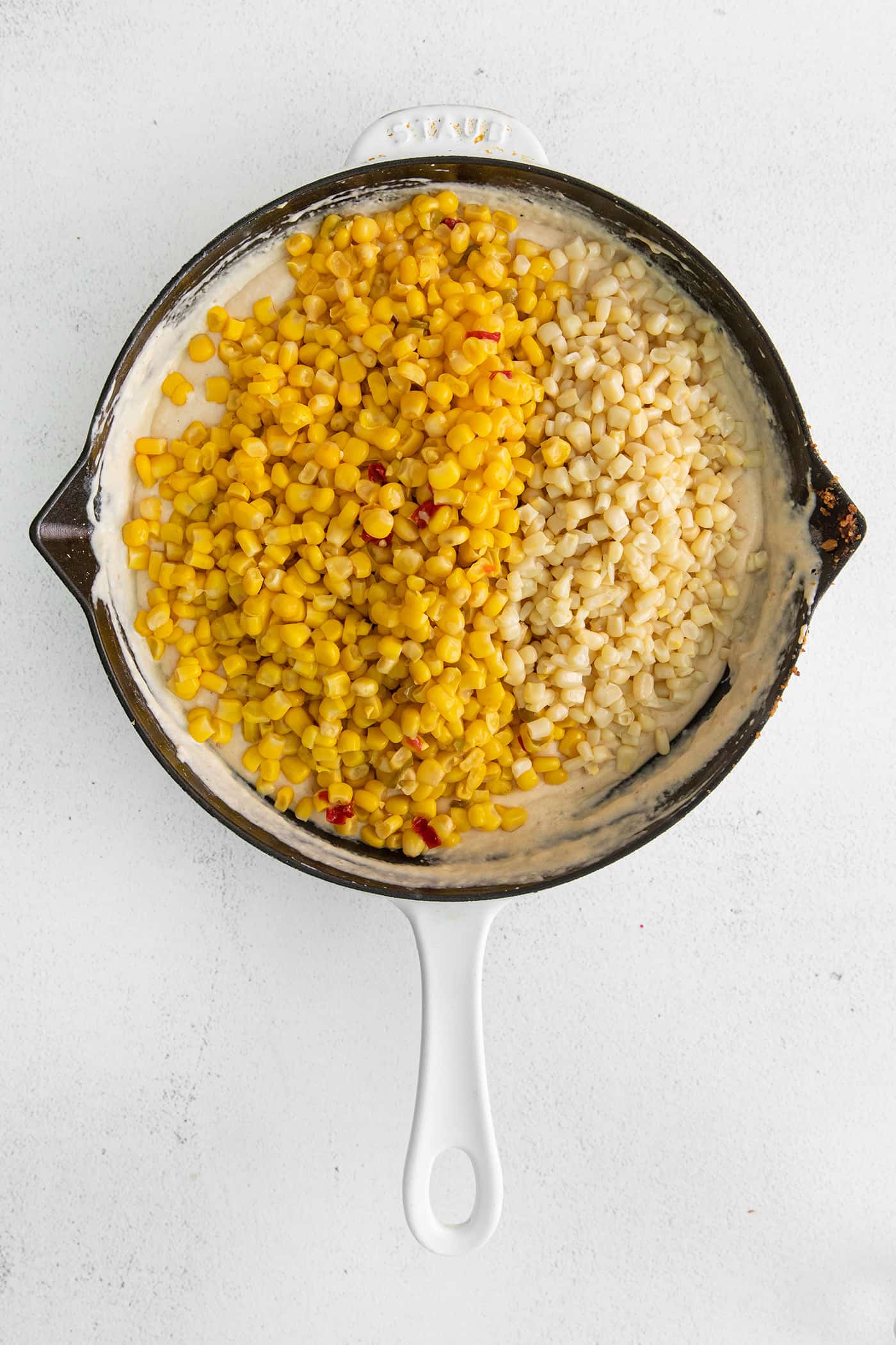 With 3 types of corn and a creamy Swiss cheese sauce, this Cheesy Skillet Scalloped Corn is a family favorite side dish! Canned corn in a cast iron skillet with cheese sauce