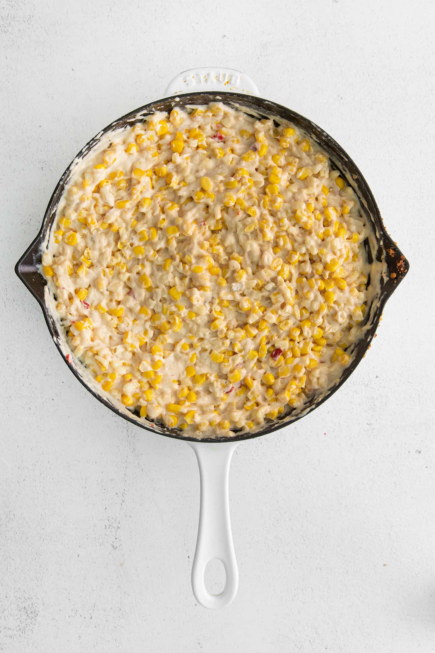 With 3 types of corn and a creamy Swiss cheese sauce, this Cheesy Skillet Scalloped Corn is a family favorite side dish! Cheesy skillet corn in a cast iron skillet