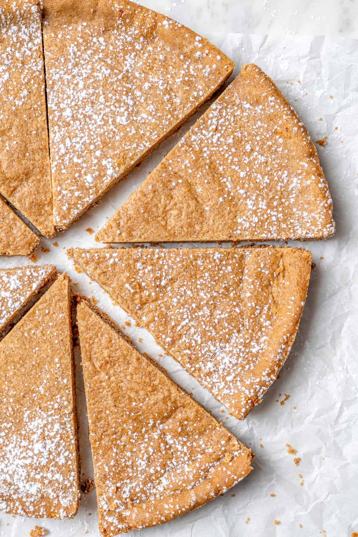 Full of warm spices, these simple spice cookies are a great addition to any holiday cookie platter. They're so easy to make too! Overhead view of spice cookies cut into wedges and dusted with powdered sugar