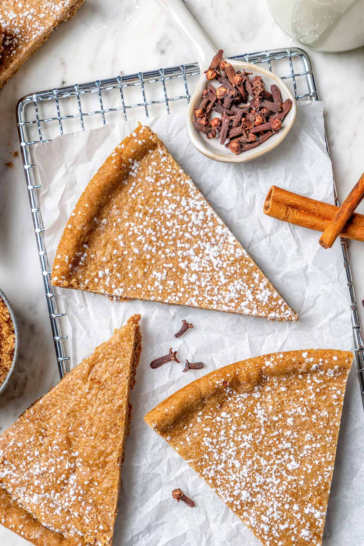 Full of warm spices, these simple spice cookies are a great addition to any holiday cookie platter. They're so easy to make too! Spice cookies dusted with powdered sugar on wire rack