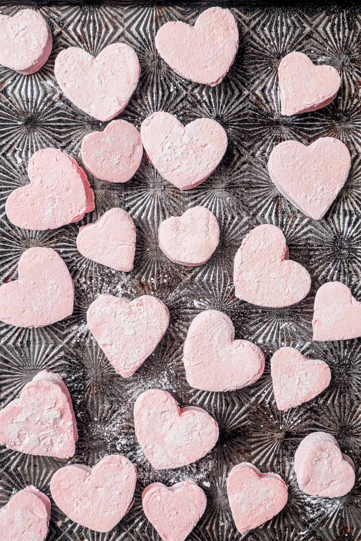 Homemade Marshmallow Hearts are the very best way to send a little love on Valentine’s Day — or any time of year. Fluffy, puffy, and sweet! Various sizes of heart marshmallows on baking sheet