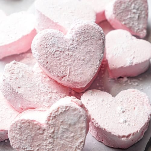 Pile of pink heart marshmallows on parchment paper