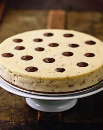 A toffee cheesecake on a white cake stand.