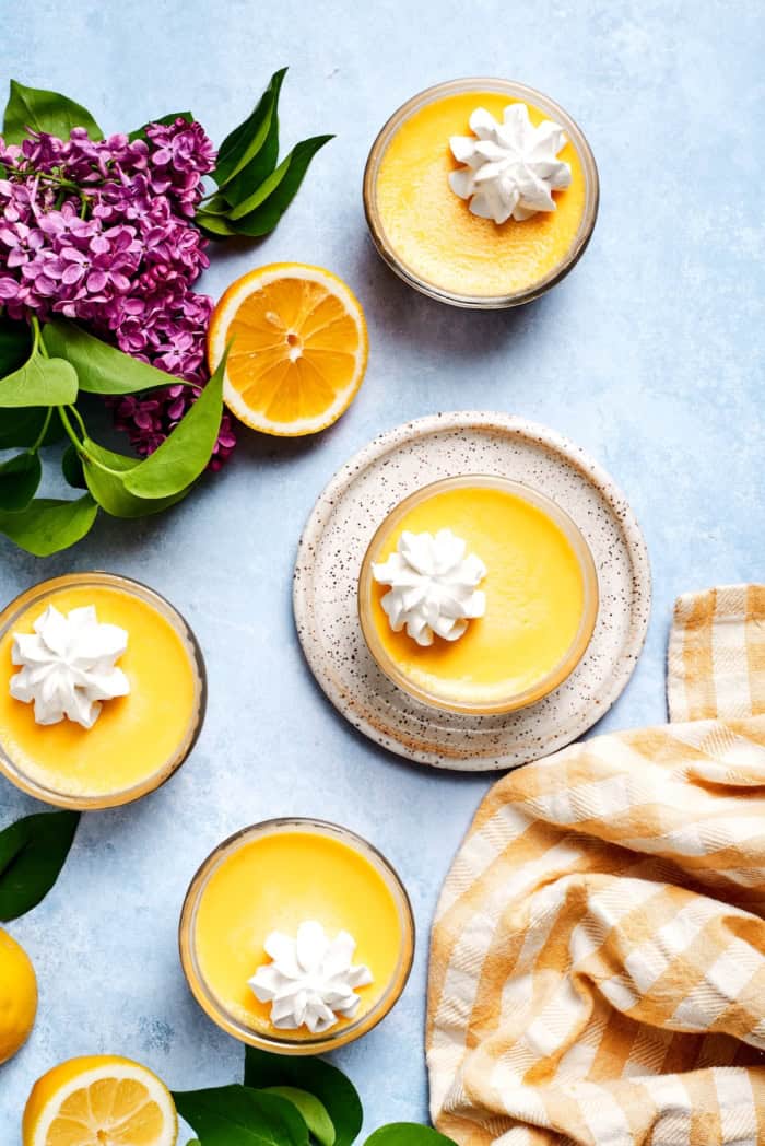 Overhead view of 4 lemon custard cups topped with whipped cream