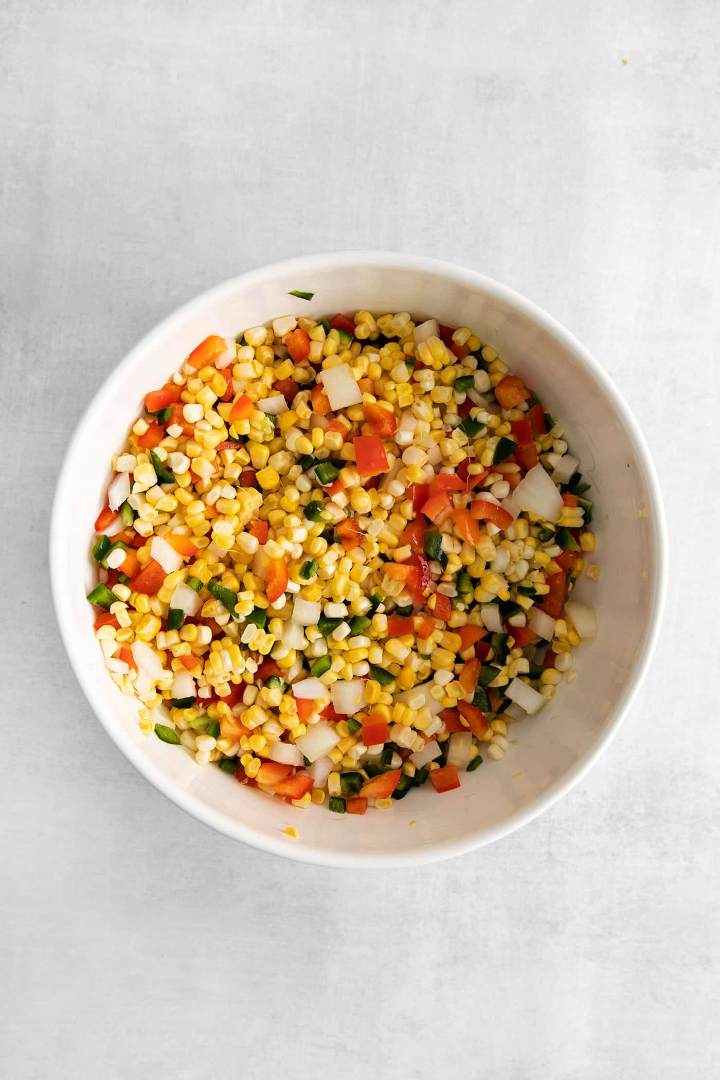 Made with fresh sweet corn, peppers, and onion this Zesty Sweet Corn Relish is just what you need to spice up dishes from tacos to burgers. Corn, peppers, and onions mixed in a bowl