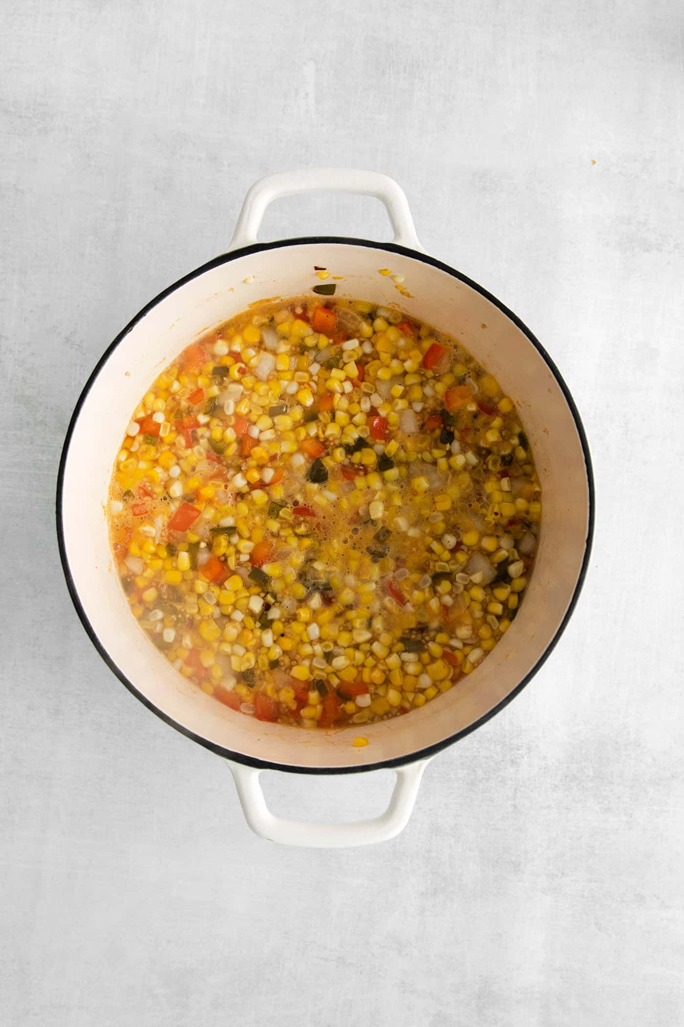 Made with fresh sweet corn, peppers, and onion this Zesty Sweet Corn Relish is just what you need to spice up dishes from tacos to burgers. Corn, peppers, and onions in a vinegar mixture in a bowl