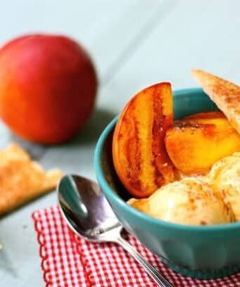 a bowl with grilled peaches, ice cream, and cinnamon pie crust