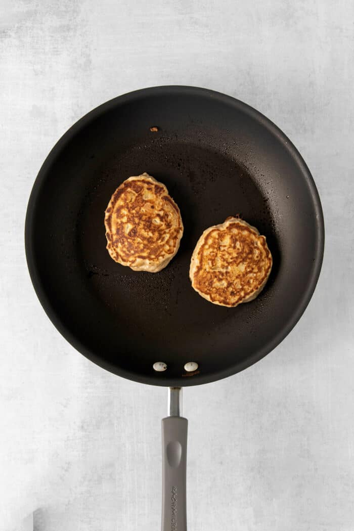 Studded with bits of apple and oats, these Apple Oatmeal Pancakes are a cozy, comforting breakfast that's hearty yet not heavy. Two apple buttermilk pancakes in a skillet
