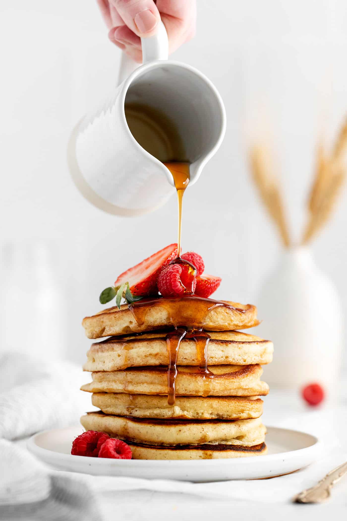 Made with pantry staples, these Buttermilk Pancakes are simply the best homemade pancakes you'll ever make! Super fluffy! Syrup being poured over a stack of pancakes