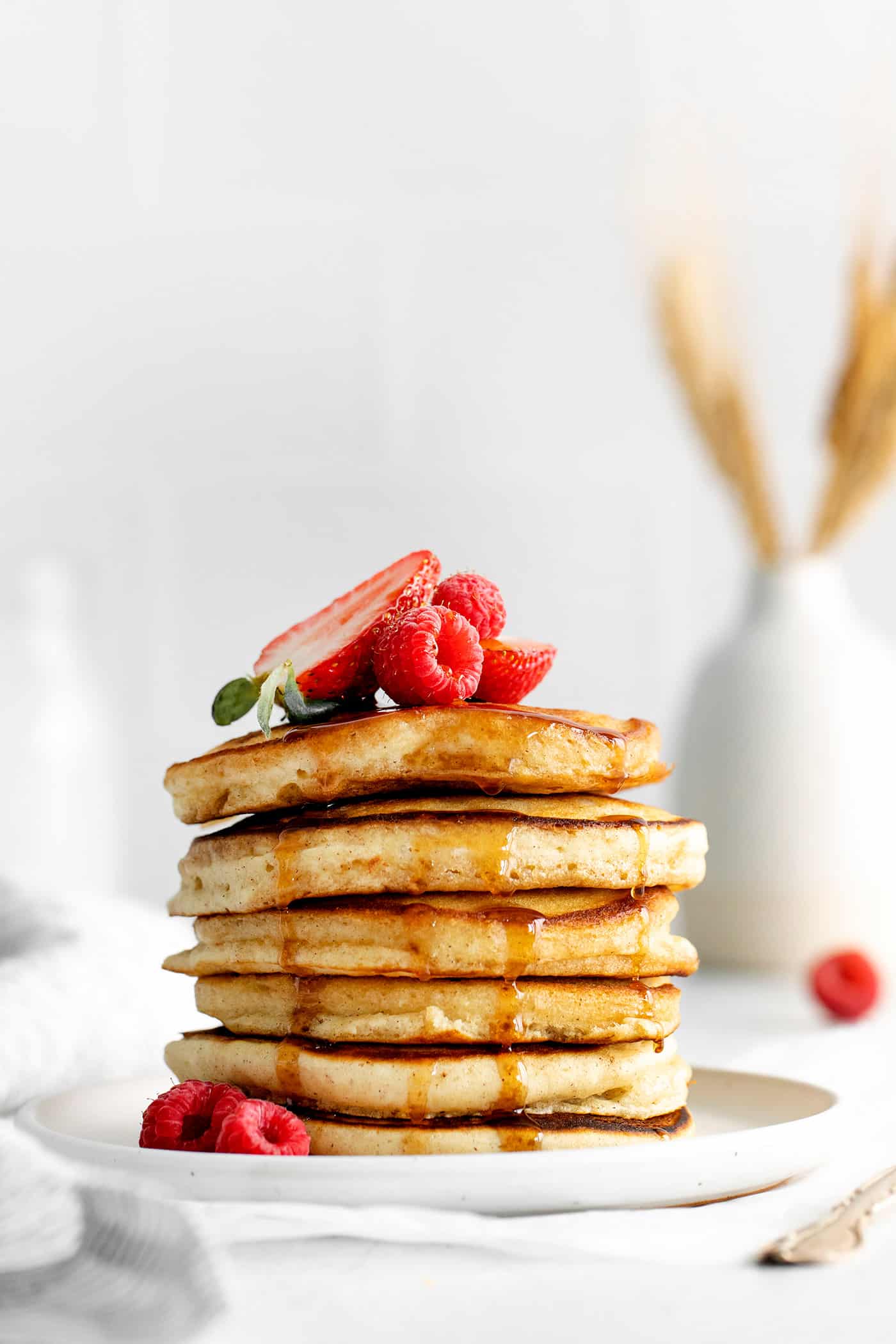 Made with pantry staples, these Buttermilk Pancakes are simply the best homemade pancakes you'll ever make! Super fluffy! A stack of buttermilk pancakes topped with strawberries