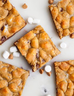 Overhead view of 5 disappearing marshmallow brownies with butterscotch chips and marshmallows