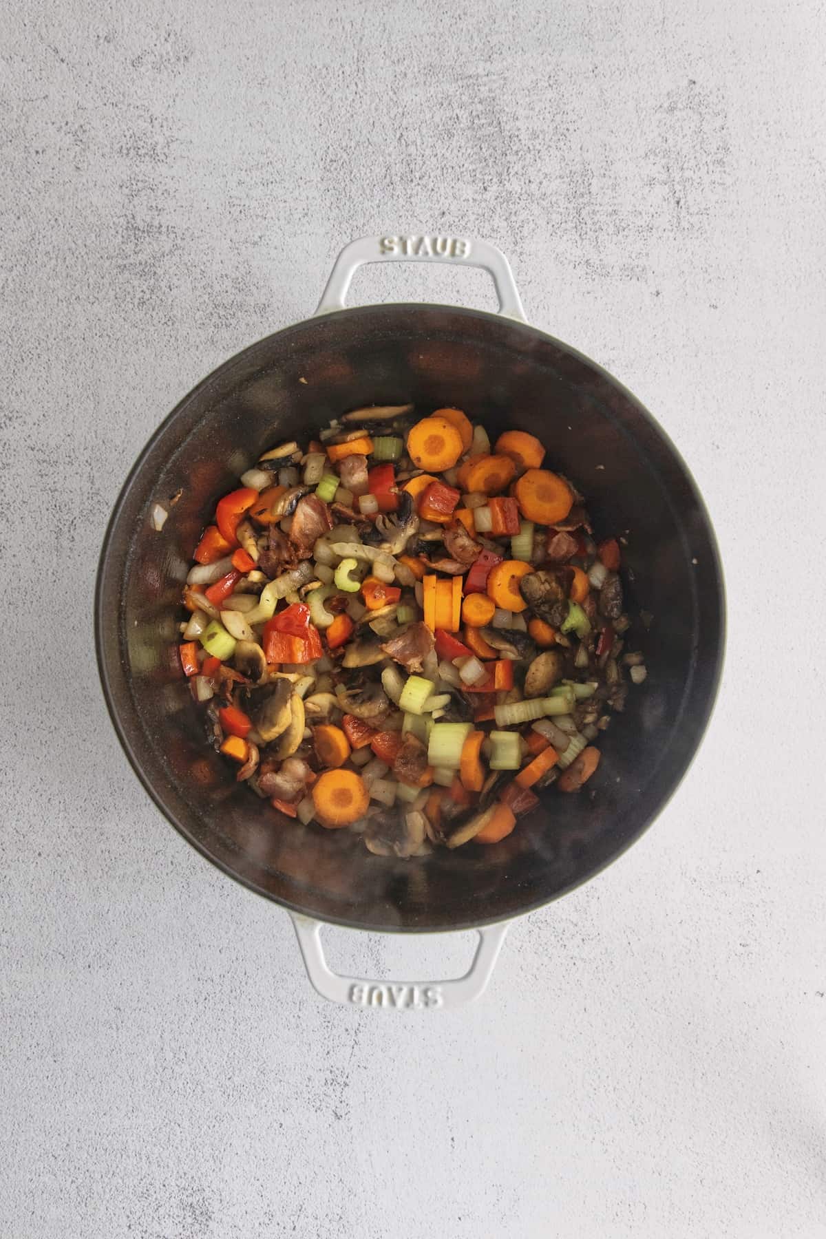 Make this easy Smoked Turkey Chowder recipe in one pot. It's lightly creamy and loaded with flavor, a great way to use up turkey leftovers! Chopped vegetables and bacon pieces in a black pot