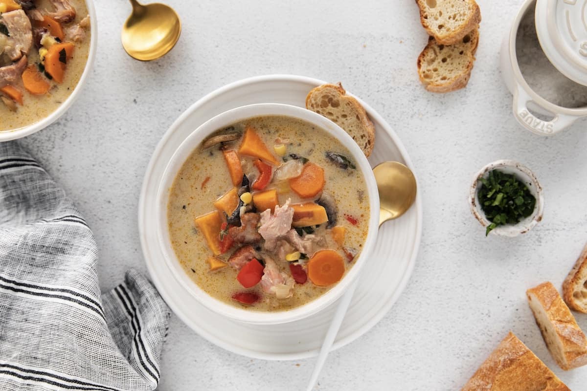 Make this easy Smoked Turkey Chowder recipe in one pot. It's lightly creamy and loaded with flavor, a great way to use up turkey leftovers! Overhead view of leftover turkey chowder in a white bowl