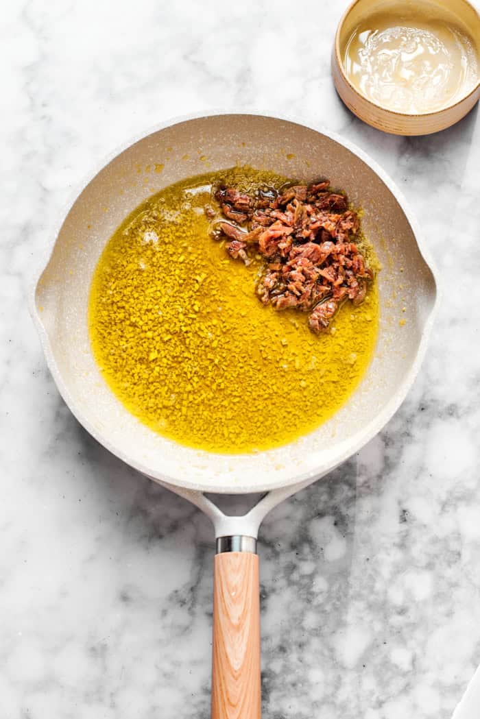 This Bagna Cauda dip is packed full of garlic and anchovies for big flavor — and it's loads of fun to eat! Easy to make in just 30 minutes! Anchovies in pan with garlic and olive oil