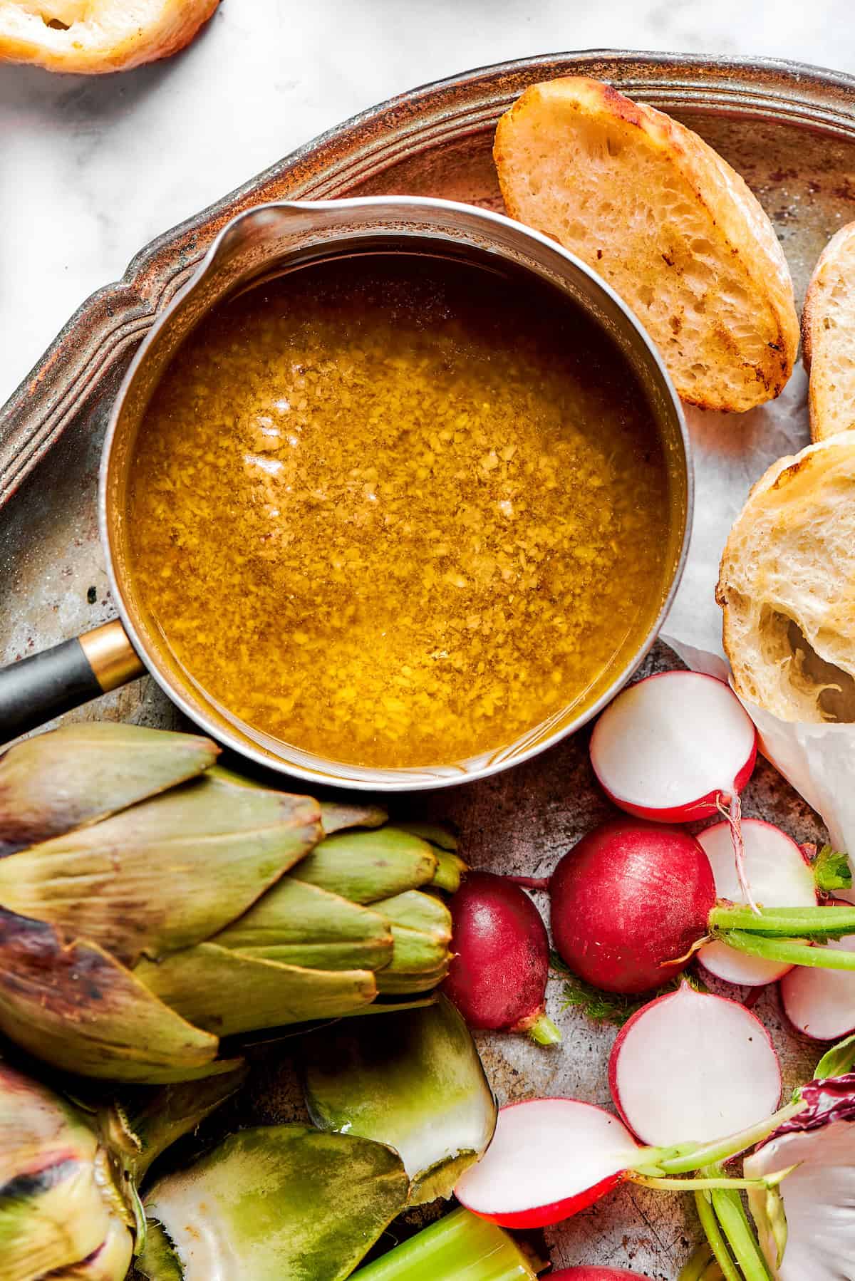 This Bagna Cauda dip is packed full of garlic and anchovies for big flavor — and it's loads of fun to eat! Easy to make in just 30 minutes! Pan of bagna cauda with vegetables and bread