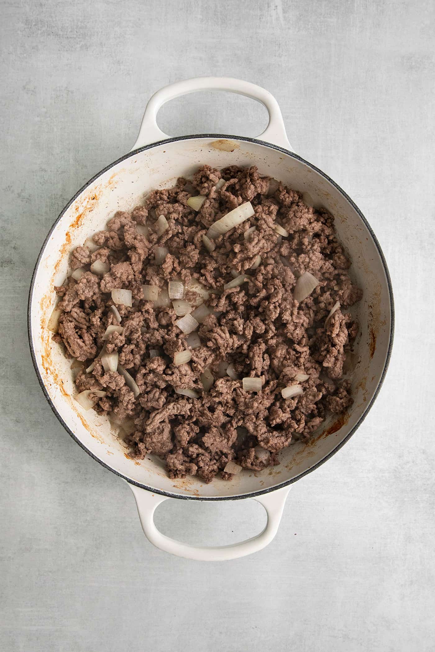 This Cheesy Beef Taco Dip is full of the beefy taco flavor you love, with ground beef, taco seasoning, Rotel, and loads of cheddar cheese. Cooked ground beef in a skillet