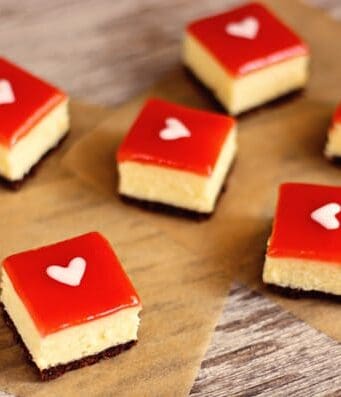 white chocolate cheesecake squares topped with strawberry glaze and a white heart