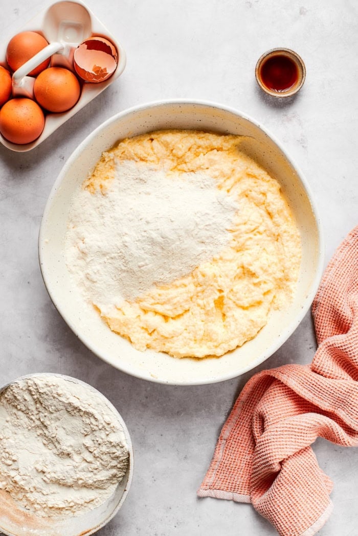 This cream cheese pound cake is a simple 6-ingredient recipe that’s rich, buttery, and perfectly dense with a velvety crumb. The best! Flour added to bowl of wet ingredients for cream cheese pound cake.