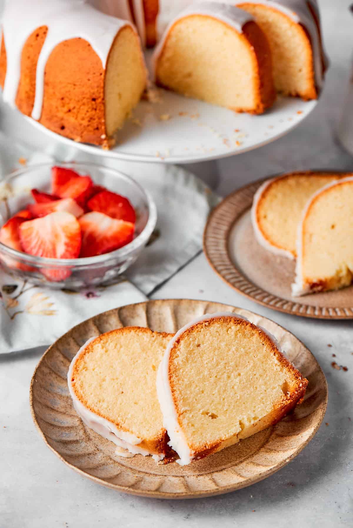 This cream cheese pound cake is a simple 6-ingredient recipe that’s rich, buttery, and perfectly dense with a velvety crumb. The best! Two plates with two slices of cream cheese pound cake.