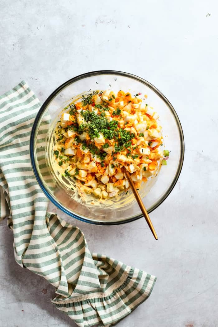 Creamy egg salad gets a fresh lift from bright herbs, making this egg salad sandwich a simple lunch that tastes anything but ordinary! Spoon in bowl of ingredients for egg salad.