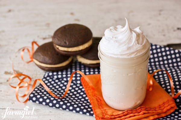 Whoopie Pies with Fluffy Peanut Butter Marshmallow Cream are the ultimate cake sandwich! It doesn't get much better than this classic peanut butter and chocolate combination. A jar of marshmallow cream next to a stack of whoopie pies.