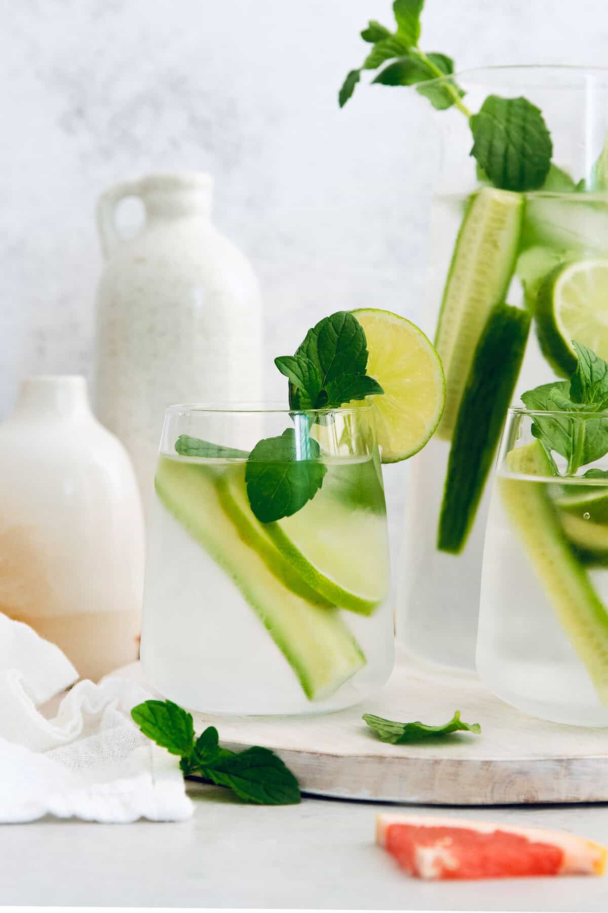 Six delicious flavor ideas for making infused spa water at home. Put extra herbs and fruit to use and make staying hydrated so much tastier! Cucumber, mint, and lame spa water in glass