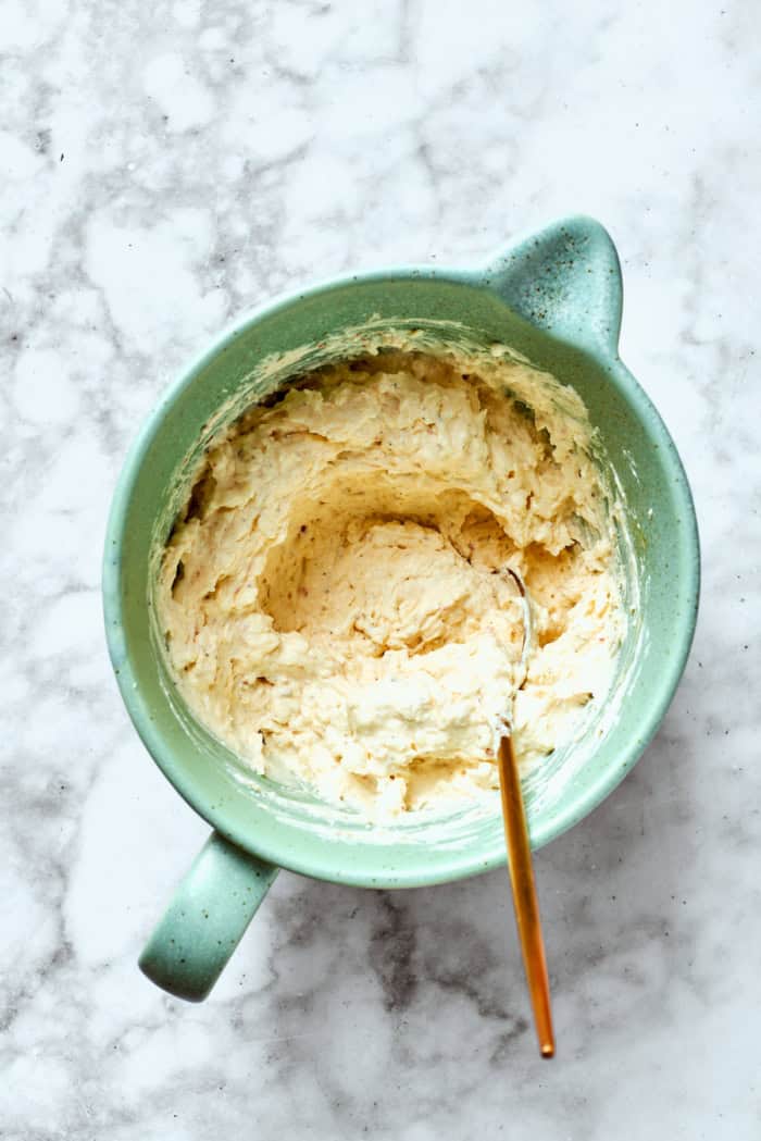 Meaty sauce, super fun spaghetti noodles, and pockets of Cheesy Yum make this Spaghetti Casserole an instant hit with the whole family! Overhead view of cheesy yum in mixing bowl with spoon