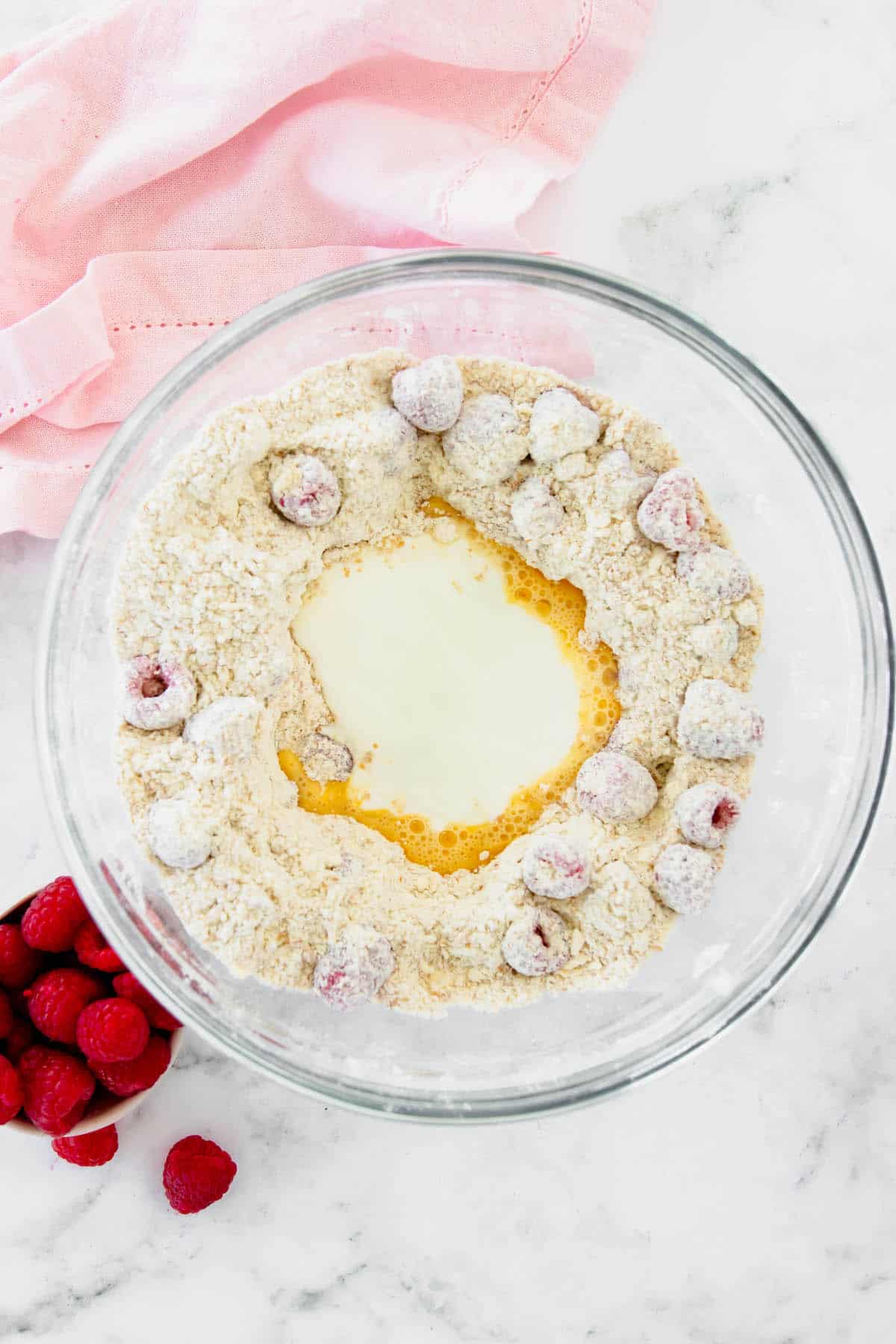 The wet ingredients for drop scones in a well created by the dry ingredients
