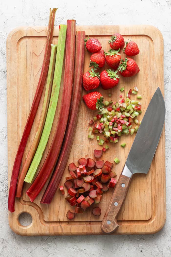 With the right balance of sweet and tart, this strawberry rhubarb freezer jam is a delight — and you don't need canning equipment to make it! Overhead view of rhubarb and strawberries on cutting board with knife