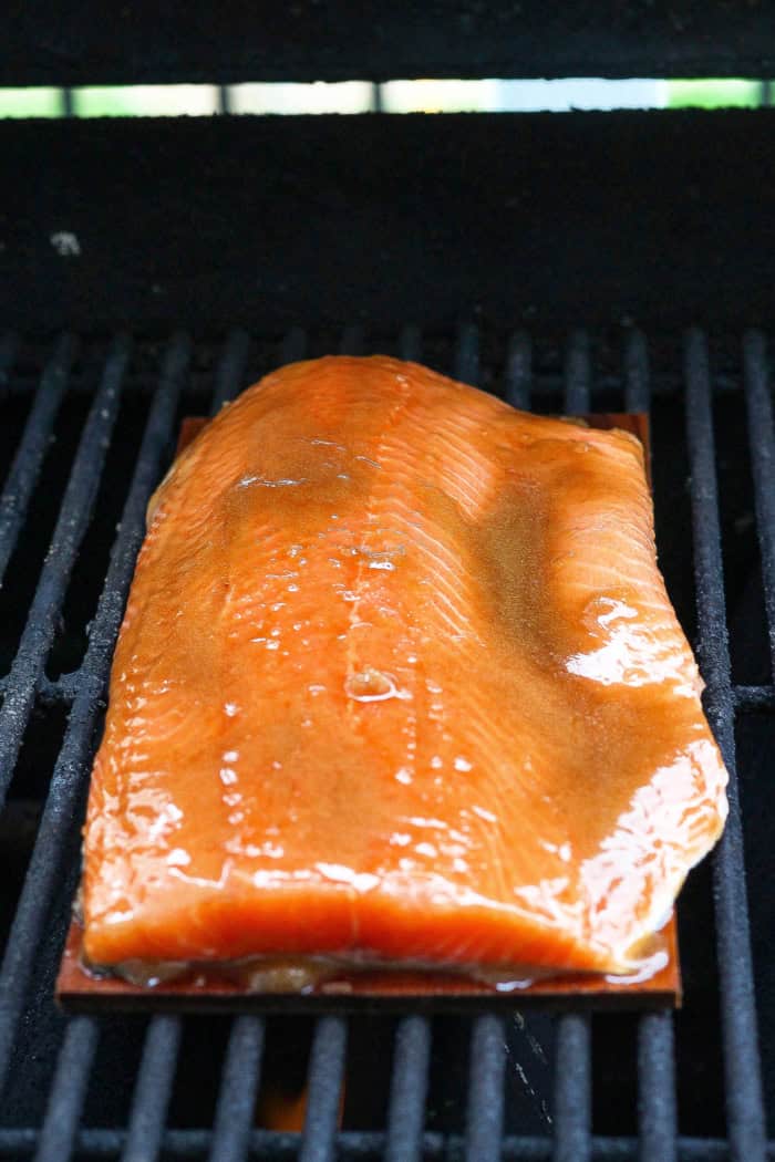 This Sweet and Smoky Grilled Salmon recipe is guaranteed to be perfectly moist, with a smoky maple brown sugar glaze that’s irresistible! Uncooked glazed salmon set on cedar plank on grill