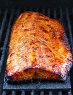 Sweet and smoky grilled salmon on cedar plank set on grill grates