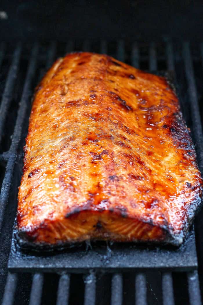 Sweet and smoky grilled salmon on cedar plank set on grill grates