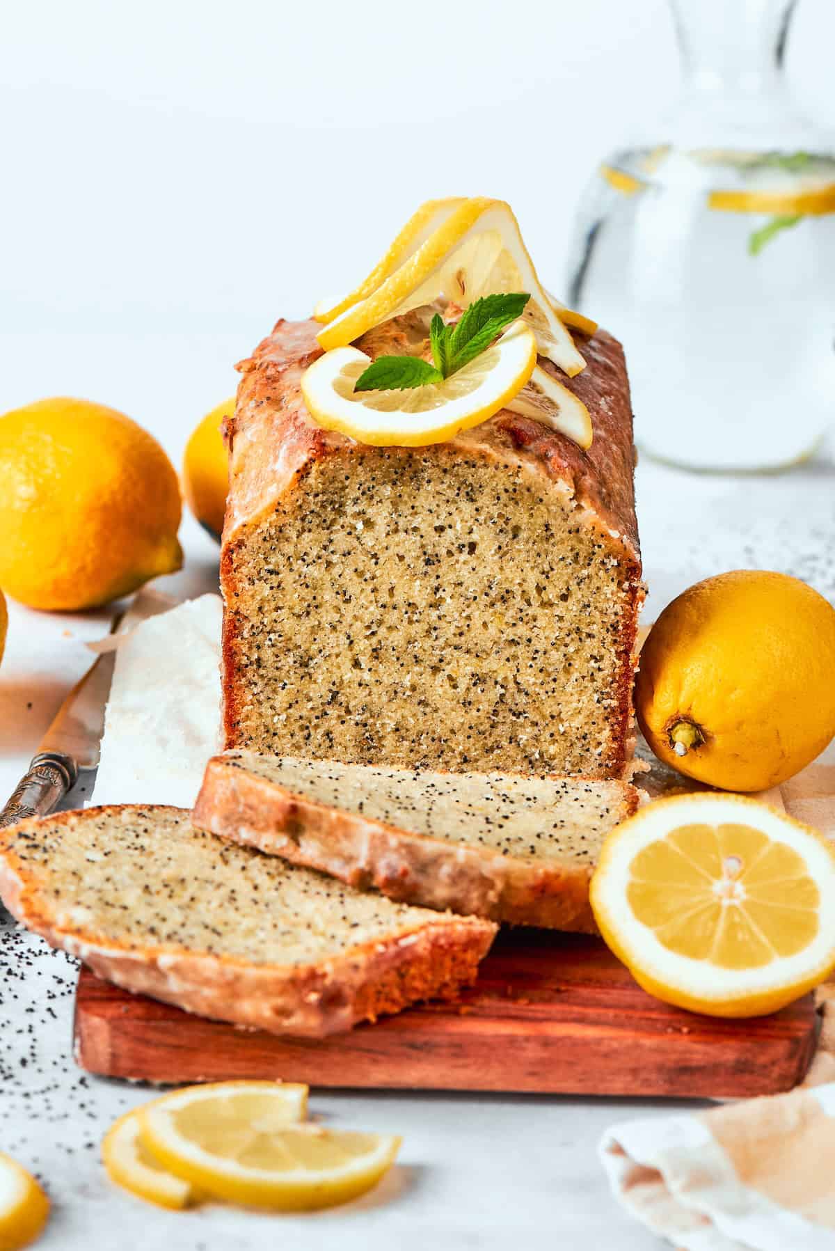 This Almond Lemon Poppy Seed Bread is soft, moist and citrusy. Topped with a zesty glaze, it’s breakfast bread worth getting out of bed for! Loaf of almond lemon poppy seed bread with two slices cut.