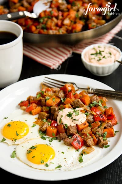 breakfast hash with two eggs and a mug of coffee