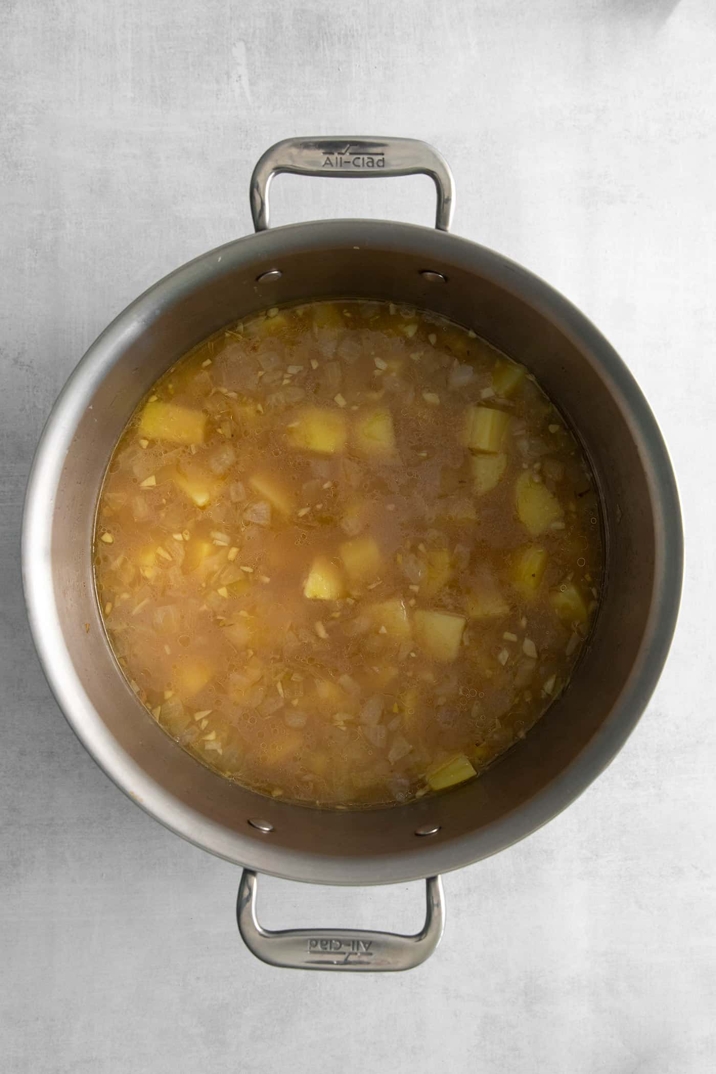 This Creamy Potato Soup with Herby Compound Butter gets everything right. It's silky smooth, rich but not heavy, and lightly buttery. Diced potato in chicken broth in a pot