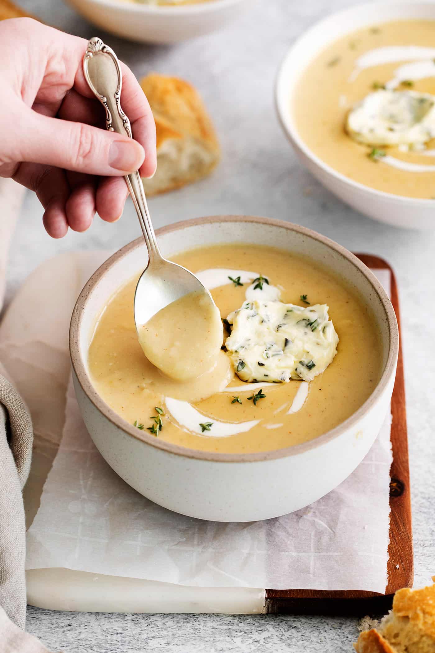 This Creamy Potato Soup with Herby Compound Butter gets everything right. It's silky smooth, rich but not heavy, and lightly buttery. A spoon stirring a bowl of potato soup