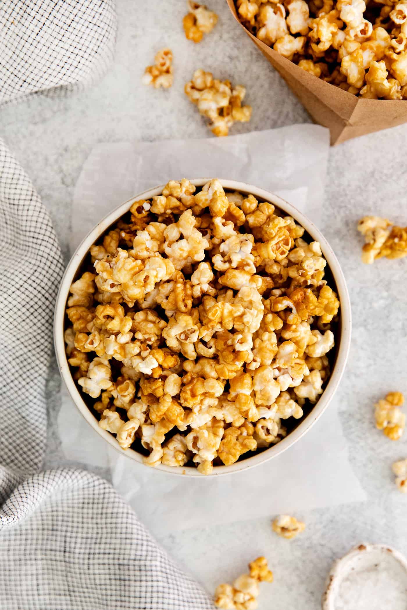 Microwave Caramel Popcorn is ready in just 15 minutes, with a handful of ingredients, a microwave, and a brown paper bag. Overhead view of a bowl of caramel popcorn
