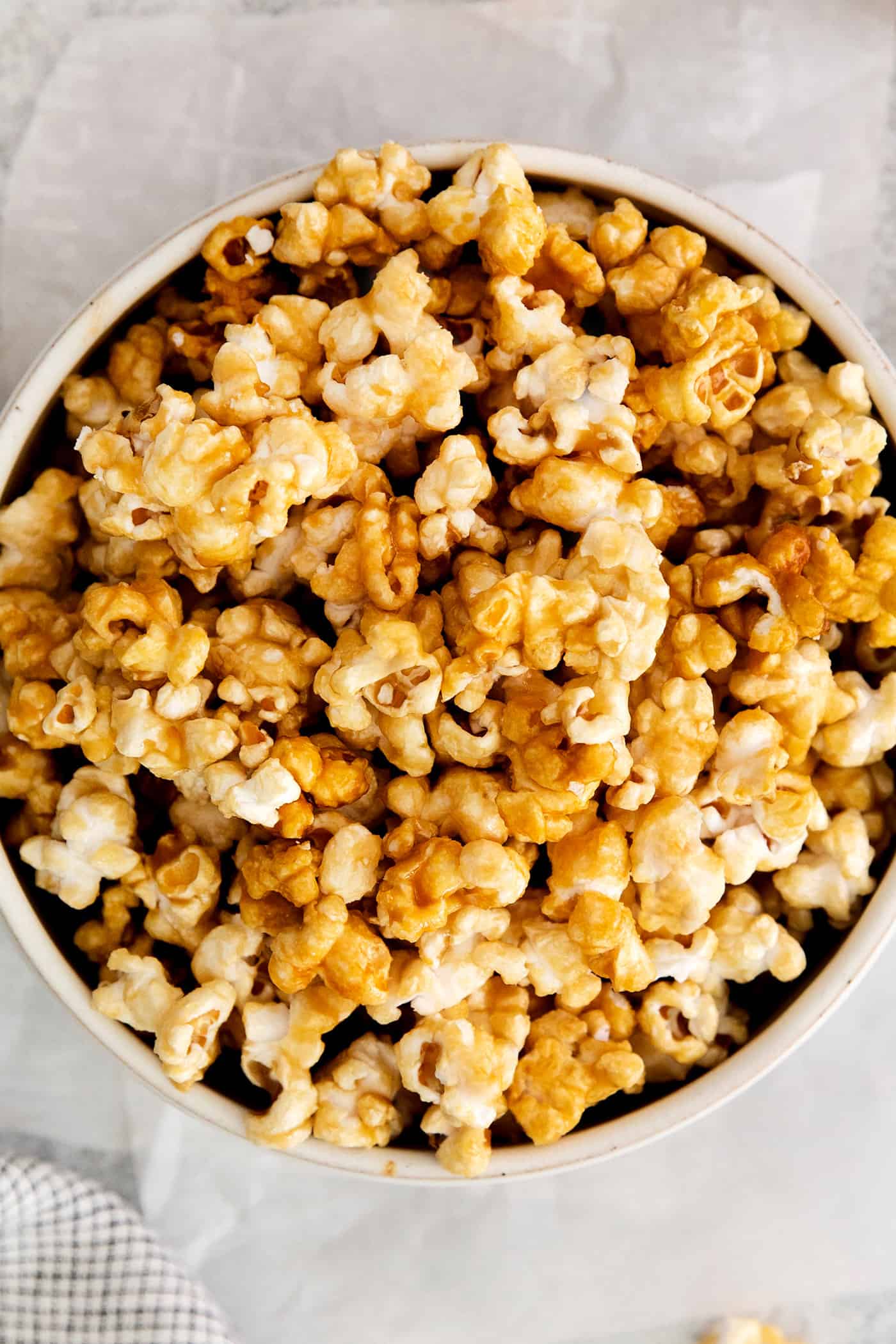 Microwave Caramel Popcorn is ready in just 15 minutes, with a handful of ingredients, a microwave, and a brown paper bag. Close up of a bowl of caramel popcorn