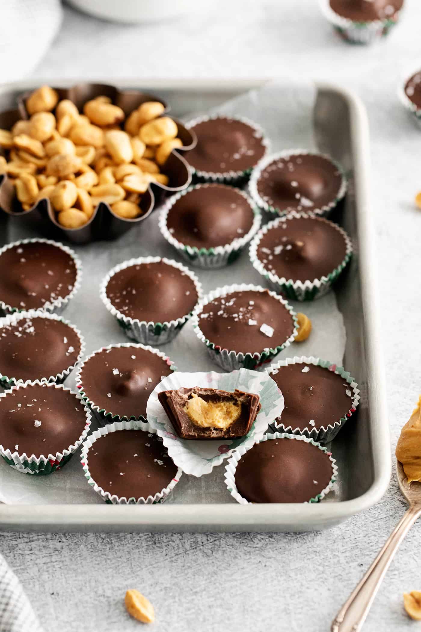 Made with just 5 ingredients, these Homemade Peanut Butter Cups are a million times better than anything you can buy at the store. Homemade peanut butter cups on a baking sheet