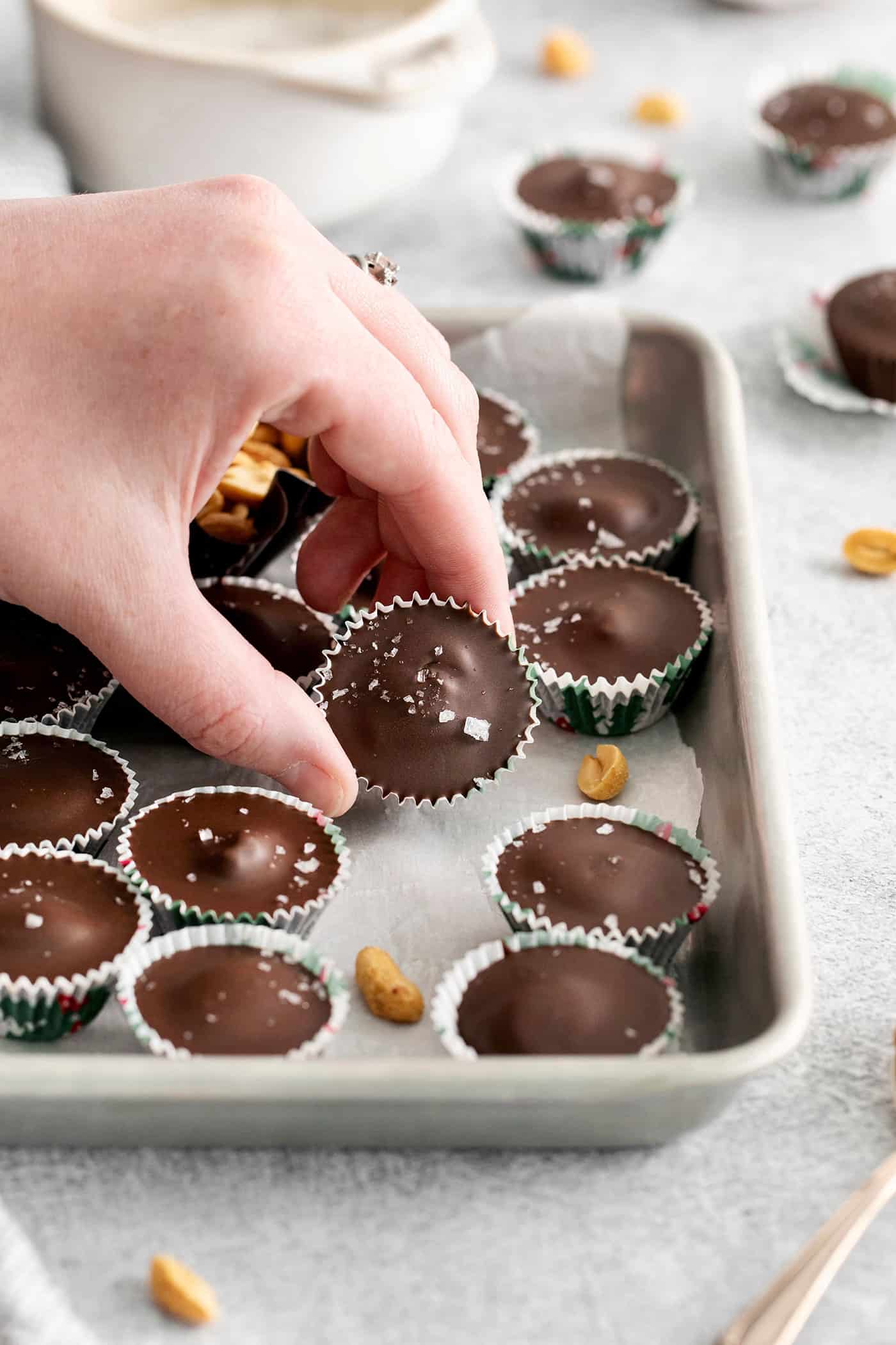 Made with just 5 ingredients, these Homemade Peanut Butter Cups are a million times better than anything you can buy at the store. A hand holding a peanut butter cup