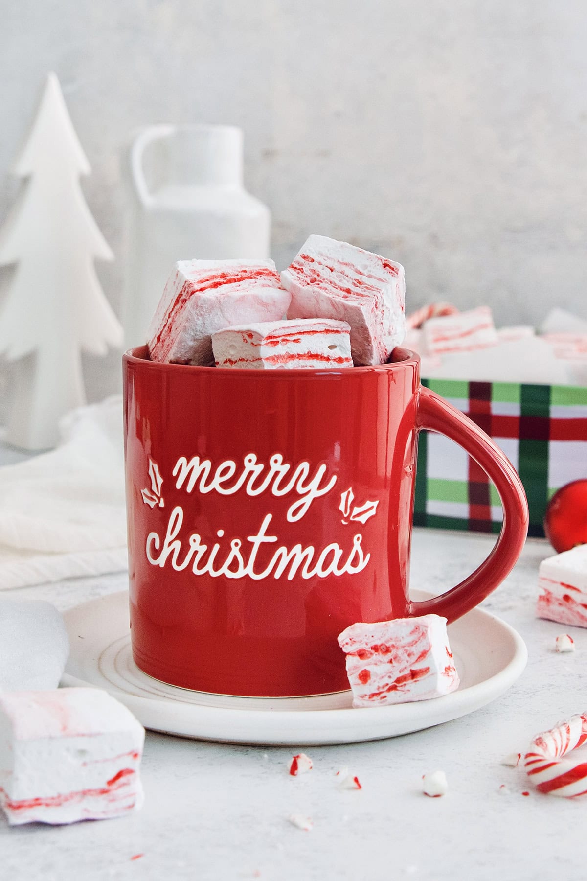Homemade peppermint marshmallows are fluffy, festive, and so delicious! They're perfect for gifting, hot cocoa, and holiday treats. Peppermint marshmallows piled into mug of hot chocolate.