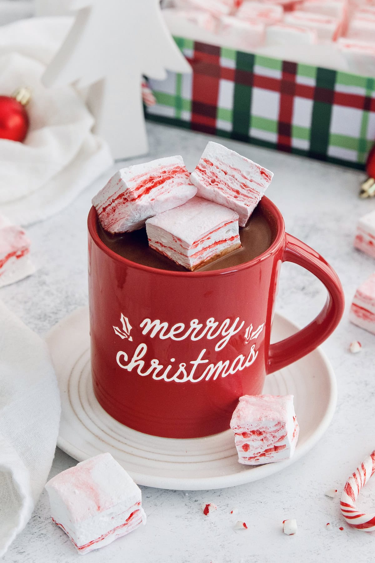 Homemade peppermint marshmallows are fluffy, festive, and so delicious! They're perfect for gifting, hot cocoa, and holiday treats. Mug of hot chocolate with peppermint marshmallows.